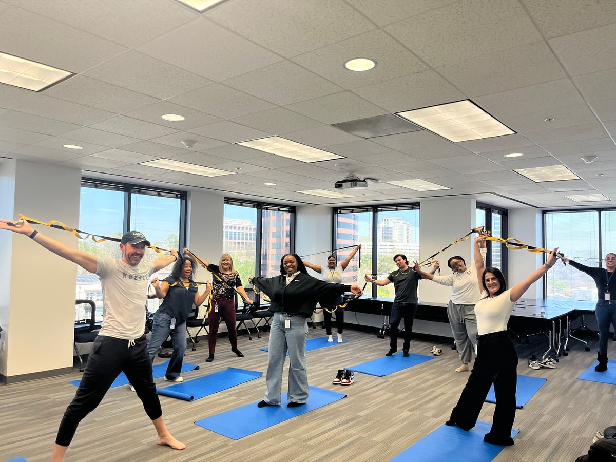 Office workers engaging in a light, guided movement session to combat sedentary work and boost energy